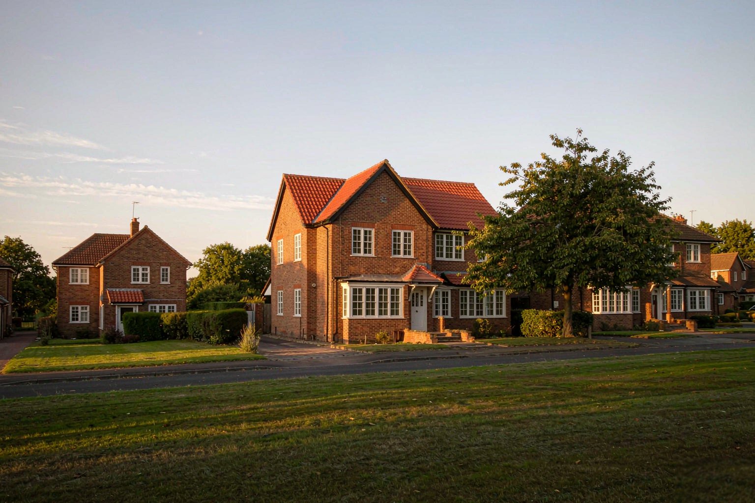 Home A quiet English residential street of brick houses at golden hour